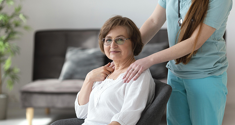 caregiver assisting elderly woman with blanket