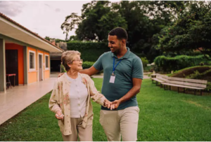 Caregiver walking with elderly woman outdoors at care facility in Hoffman Estates IL